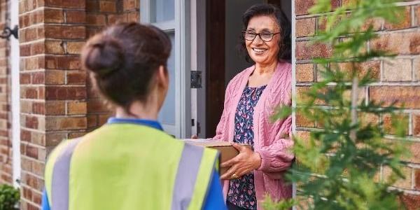 Delivery driver handing customer parcel